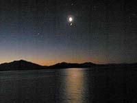 Moon and planets at sunset over Chilean fjord